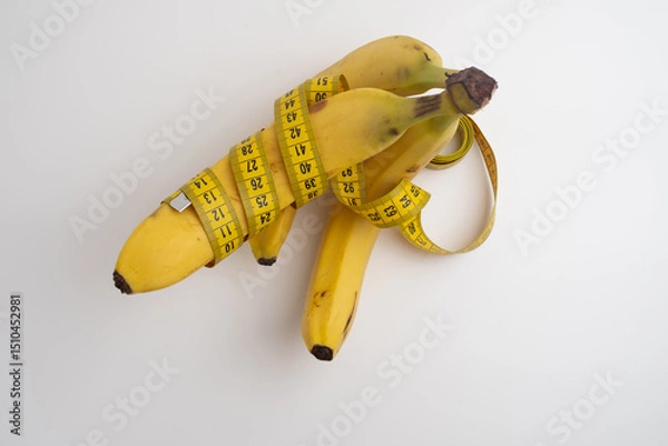 Fototapeta Yellow banana with measuring tape on light background.
Weight loss concept. Men's health concept.