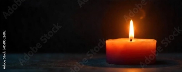 Fototapeta A flickering candle flame casts a warm, inviting glow against a dark background, creating a serene and peaceful ambiance Perfect for themes of relaxation, meditation, and spirituality , energy, hygge