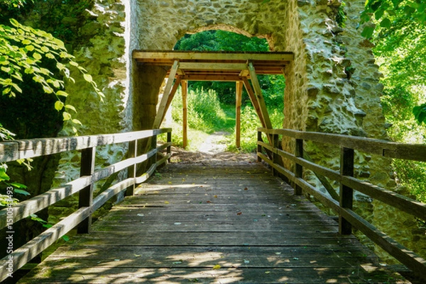 Fototapeta Wooden bridge in a forest along the trekking path.Old wooden bridge over creek.
