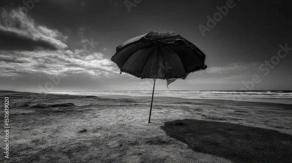 Fototapeta Serenity at the Beach: A Solitary Umbrella Casting Shadows on Sand Under a Dramatic Sky