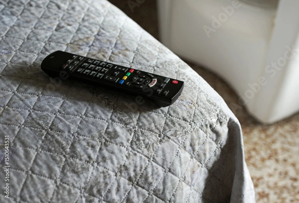 Fototapeta tv remote control on the bed