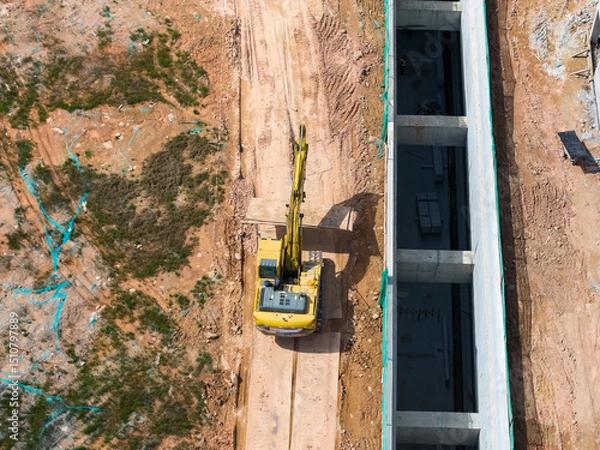 Obraz Excavator on earthmoving with grab crane with freight car,aerial view.