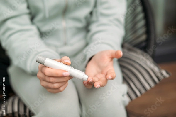 Fototapeta A person using a glucometer to check blood sugar levels, emphasizing healthcare, diabetes monitoring, and self-care practices.