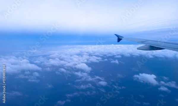 Obraz Plane flying over clouds, aerial view from airplane window, fluffy cloudscape and blue sky