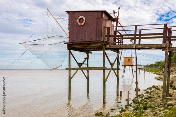 Obraz Fishing huts on stilts in Lamarque, Gironde estuary, inspired by Chinese fishing nets, called Carrelets in France, still popular in South West France by the Atlantic Ocean
