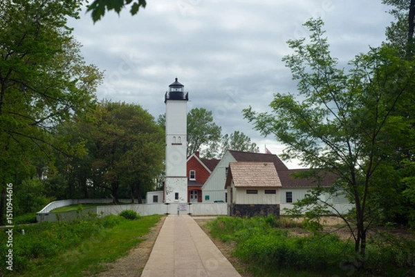 Fototapeta The old lighthouse and adjoining structures at Presque Isle State Park on Lake Erie in Pennsylvania under cloudy skies in late spring