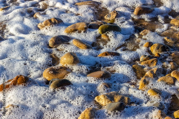 Obraz Ocean foam meets pebbled shore in a quiet meditation on presence and flow