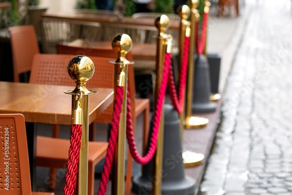 Obraz A gold fence post with red rope.