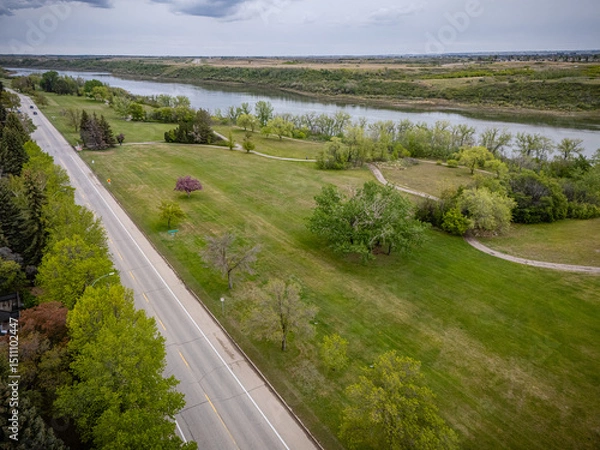 Fototapeta Road with trees and a river in the background