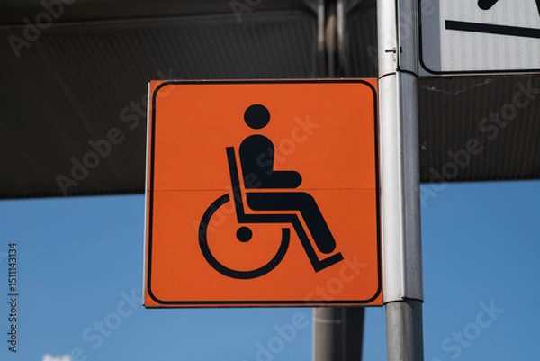Fototapeta Slope road warning sign, signage indicates accessibility with sloping asphalt sidewalk, useful for wheelchair access as indicated by the highway code, now common in urban areas of the city. news.