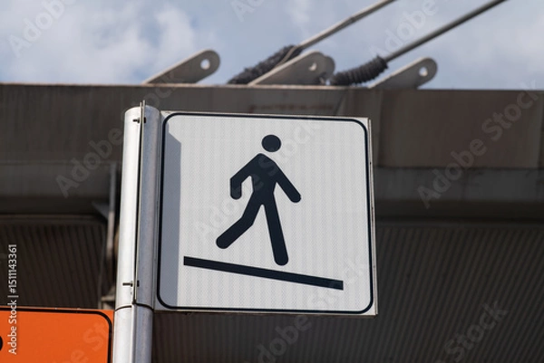 Fototapeta Slope road warning sign, signage indicates accessibility with sloping asphalt sidewalk, useful for wheelchair access as indicated by the highway code, now common in urban areas of the city. news.