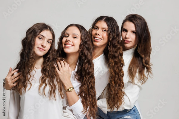 Fototapeta Group of four smiling young women enjoying each other's company