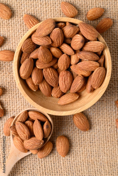 Obraz Raw almond nut seed in wooden spoon and bowl, Top view