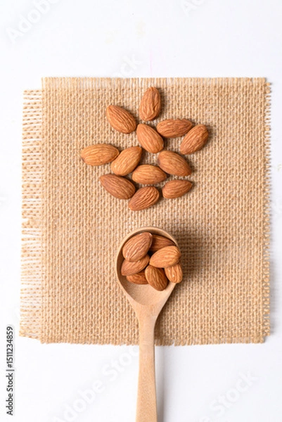 Obraz Raw almond nut seed in wooden spoon, Top view