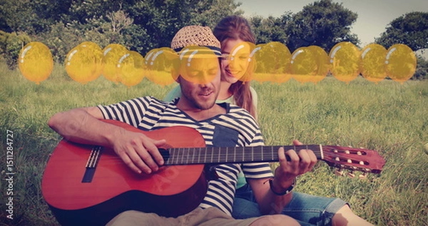 Obraz Image of balloons icons over happy caucasian couple playing guitar