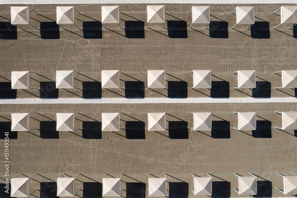 Obraz Perfect geometry of shadows and umbrellas on a deserted beach seen from above