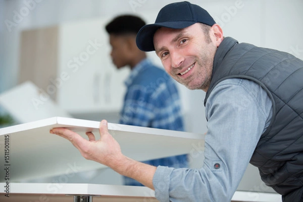 Obraz two men assembling a kitchen cupboard