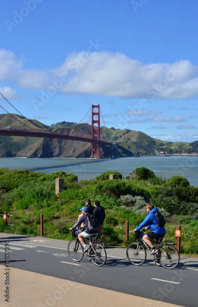 Obraz Tourists riding bikes near the Golden Gate