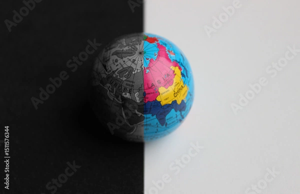 Obraz Asian Continent on Small Globe with Trade Routes Splitted with Straight Border on Colored and Grayscale Parts. Globe Split in Color on a Border Between Black and White Surfaces over Asia