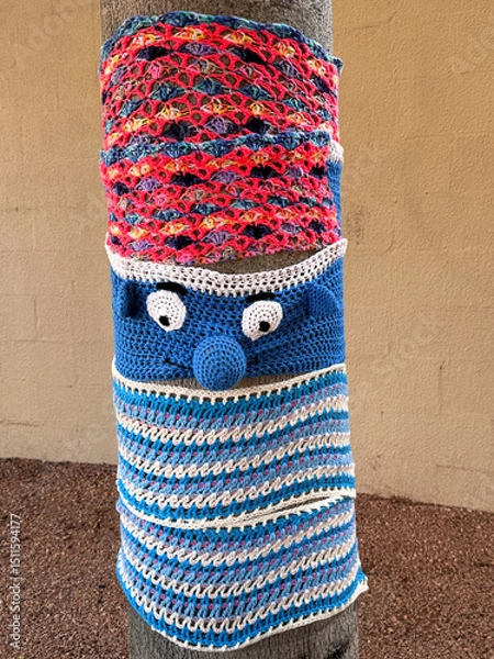 Obraz tree trunk covered in colorful crochet knitted yarn bombing