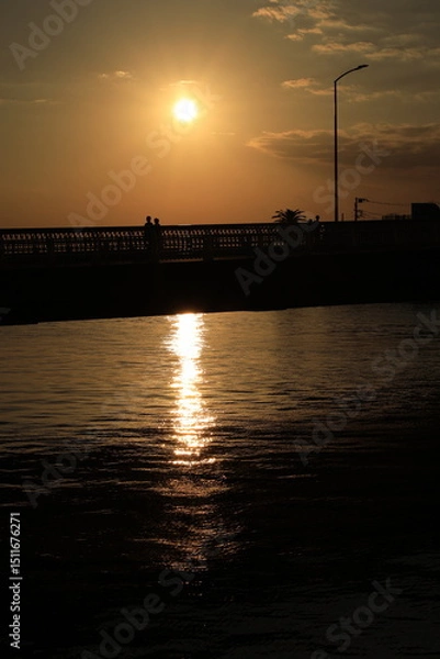 Obraz 江ノ島近くの片瀬橋から見る夕日が海に沈む夕景