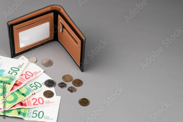 Fototapeta Israel currency New Israeli shekel (NIS) banknotes and agorot coins and empty wallet, concept of saving money, inflation, economic crisis, rising prices, and personal finances.