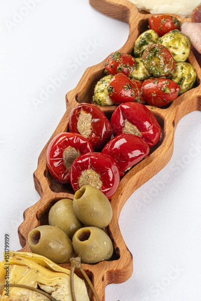 Fototapeta Wooden platter of starter appetizers with olives and pepper