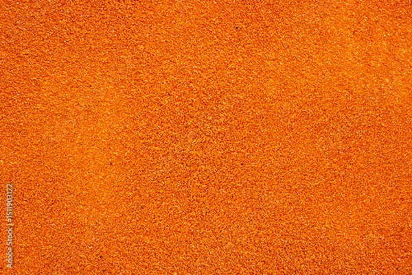 Fototapeta A detailed closeup image showing a vibrant pile of orange glitter