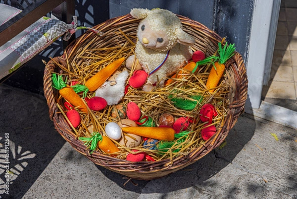 Fototapeta Little Lamb With Easter Eggs and Carrots in Straw Basket Spring Decoration