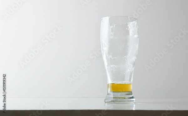 Fototapeta Empty and dirty beer glass with foam isolated on table