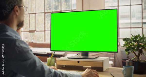 Fototapeta Professional Black Female Using Green Screen Monitor for Content Creation. Creative working on Chroma Key Display. Modern Home Office with Minimalist Interior. Over the Shoulder Shot