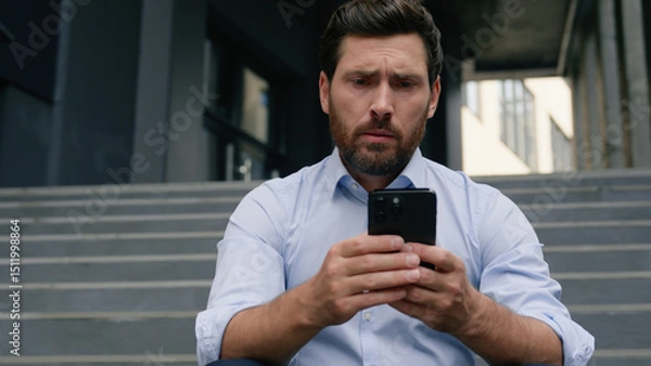 Fototapeta Stressed unemployed fired business man with dismissal box chatting phone searching new job online service dismiss businessman upset in city financial crisis holding smartphone near office building