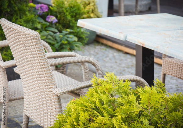 Obraz Chairs made of wicker or rattan and tables on restaurant terrace. Relaxation time on fresh air