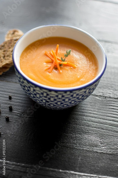 Fototapeta Carrot Soup Served in Bowl with Bread. Homemade Cream Carrot and Potato Pottage.