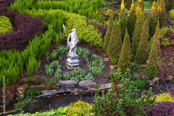 Obraz High angle view of stone Neptune statue in formal garden with shrubs, plants and narrow stream seen during a spring morning, Saint-François, Island of Orleans, Quebec, Canada
