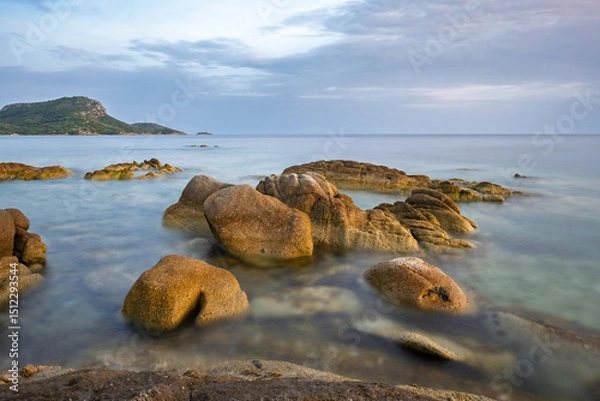 Fototapeta Evening tranquility at a coastal landscape with smooth rocks and gentle waves in Toroni on Sithonia peninsula, Greece