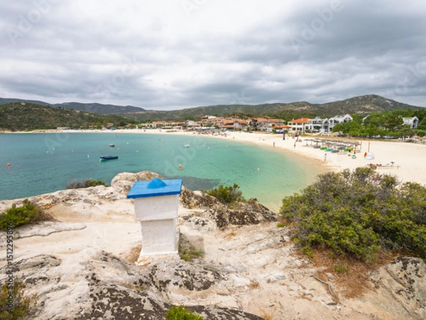 Fototapeta Scenic coastal view of a tranquil beach with boats and distant hills on a cloudy day at village Kalamitsi on Sithonia peninsula, Greece