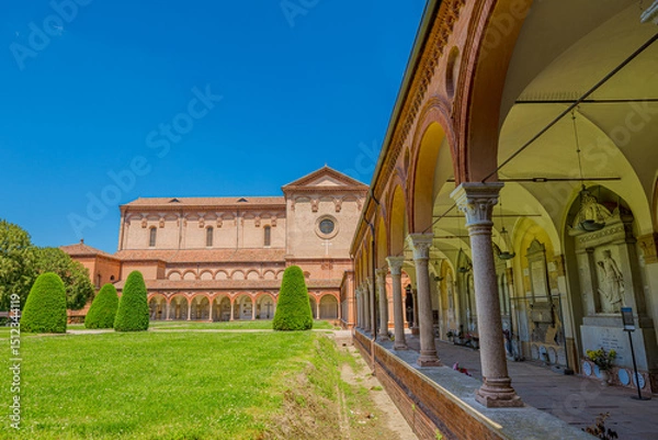 Fototapeta  Ferrara, Italy - May 17, 2025: Wide angle view of San Cristoforo church in Charterhouse of Ferrara cloister with columns framing the main building. Summer day in Ferrara, Italy