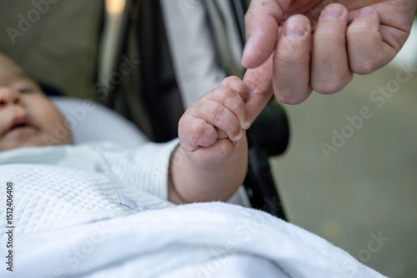 Fototapeta The gentle touch of a mother hand with her newborn baby. Fingers confidently holding the mother finger, as if this is the most important and safest place in the world.