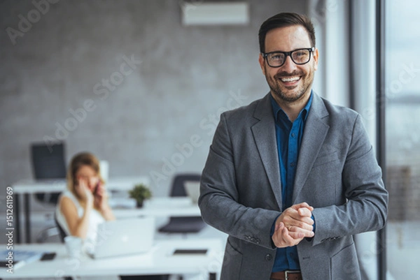 Fototapeta Smiling Businessman Posing in a Modern Office Environment