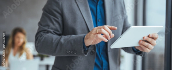 Fototapeta Businessman Using a Tablet in an Office Setting During a Work Meeting