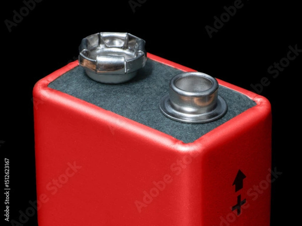 Obraz Close-up of a 9V battery displaying the positive terminal indicator on a black background