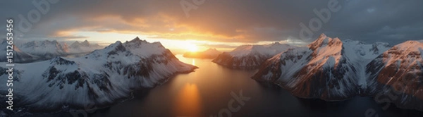 Obraz A beautiful northern landscape at sunset, with snow-covered mountains and a lake.