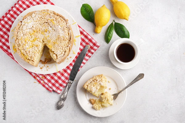 Obraz Homemade Italian lemon pie with streusel on light table with cut piece and cup of coffee, red napkin, top view, copy space
