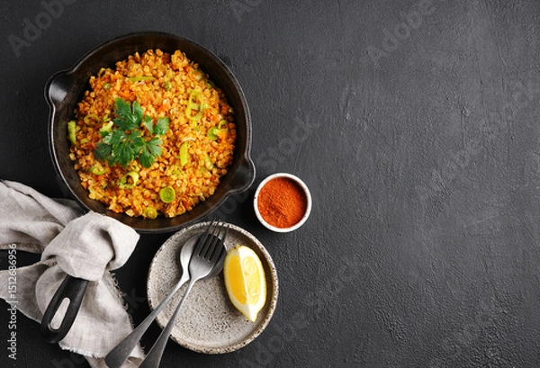 Obraz Bowl with red lentil with leek on black background. Vegan cuisine. top view , copy space