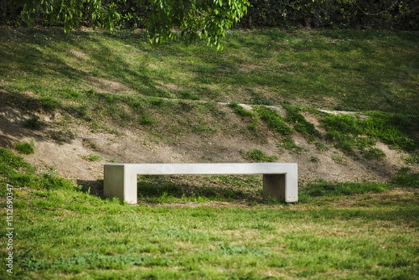 Obraz Minimalist concrete bench in sunlit park surrounded by greenery