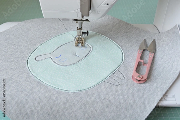 Fototapeta Cute sheep applique working process: sewing machine, thread snippers and fabric pieces