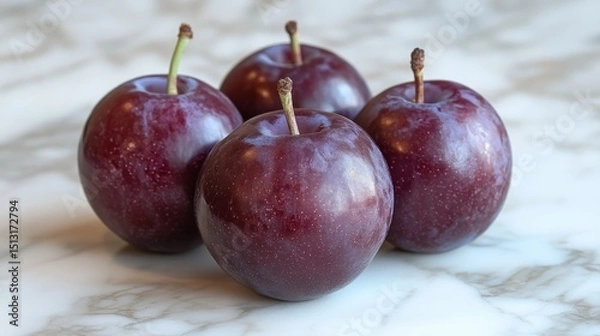 Fototapeta Close-up Arrangement of Fresh Plums Displaying Deep Purple Hues and Delicate Stems on Marble Countertop