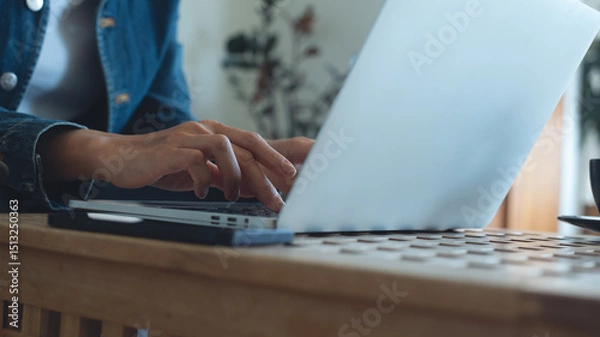 Obraz Woman working on laptop computer on table in coffee shop, freelance at work. Woman online working, typing on laptop computer, surfing the internet at cafe, remote work, online job, close up