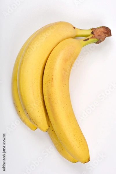 Obraz A top-down view captures a small bunch of ripe yellow bananas against a plain white background